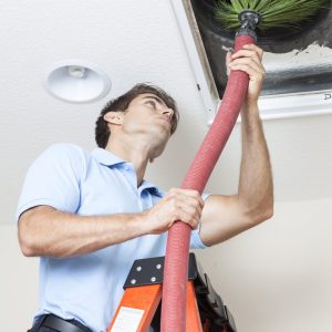 Man cleaning air ducts in home.